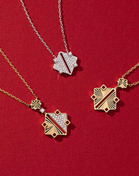 Trois colliers Birks Muse en or sur un fond rouge.